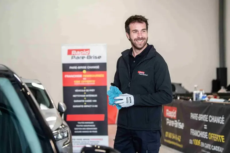 Expert qui nettoie une vitre de voiture