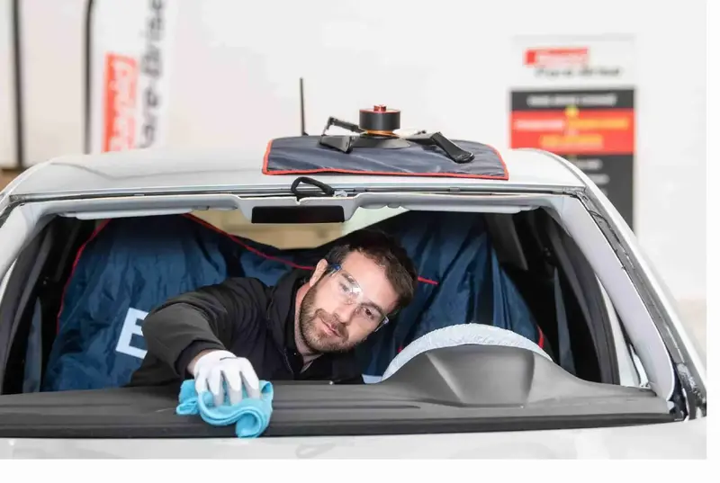 Expert qui nettoie un pare-brise de voiture